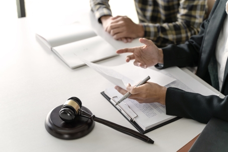 Two people scanning a document on top of a white table.