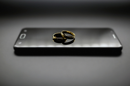 Golden wedding rings on a mobile phone